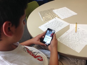 A student reads an article from Newsela on his smartphone